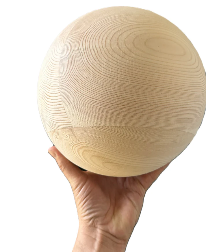 A 20cm solid wood ball held in one hand to show its size